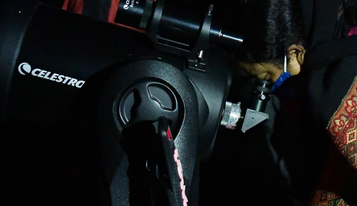 Seorang wanita menyaksikan fenomena "konjungsi besar" planet Jupiter dan Saturnus di Udaipur, 50 kilometer dari Agartala, India timur laut (22/12/2020). Konjungsi besar yang begitu spektakuler ini, terjadi karena kesejajaran planet, belum terjadi dalam hampir 800 tahun. (Xinhua/Str)