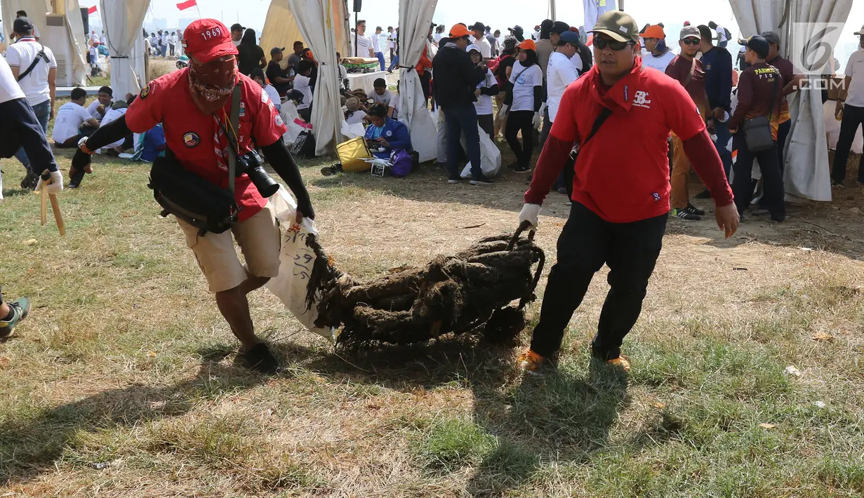 Relawan mengangkut sampah di pantai timur ancol, Jakarta, Minggu (18/8/2019). Aksi tersebut berupa kegiatan bersih-bersih pantai dari sampah plastik yang akan digelar serentak di 74 titik yang tersebar di berbagai daerah di Indonesia. (Liputan6.com/Herman Zakharia)