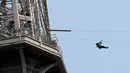 Aksi seorang pengunjung menaiki flying fox dari Menara Eiffel, Paris, 5 Juni 2017. Kesempatan ini dibuka untuk umum jelang turnamen tenis French Open agar dapat merasakan bagaimana kecepatan bola tenis yang dipukul oleh petenis (AP Photo/Kamil Zihnioglu)