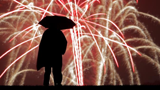Seseorang menyaksikan pertunjukan kembang api pada perayaan Hari Kemerdekaan Amerika Serikat atau dikenal sebagai Fourth of July dari Liberty Memorial di Missouri, Kamis (4/7/2019). Perayaan Empat Juli ini mengenang deklarasi kemerdekaan Amerika dari Inggris pada tahun 1776 (AP Photo/Charlie Riedel)