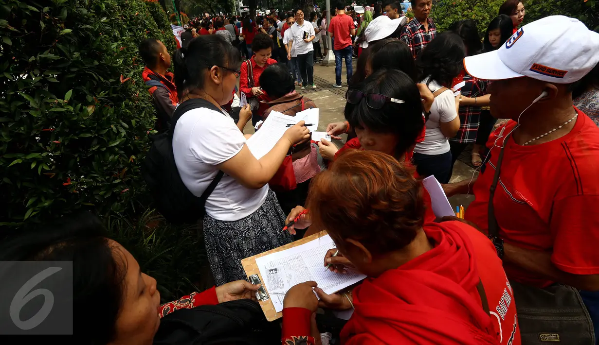 Sejumlah warga mengisi formulir pendataan dan pengumpulanKTP di depan Balai Kota, Jakarta, Kamis (5/11). Pendataan dan pengumpulan KTP tersebut sebagai petisi penangguhan penahanan Ahok sebagai Tahanan Kota. (Liputan6.com/Johan Tallo)