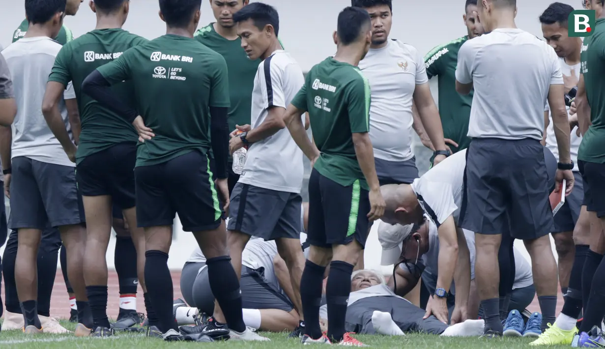 Dokter Timnas Indonesia, Syarif Alwi, memeriksa Danurwindo, yang pingsan usai memantau latihan di Stadion Wibawa Mukti, Jawa Barat, Sabtu (03/11/2018). Danurwindo ambruk ketika tim dan ofisial melakukan sesi foto bersama. (Bola.com/M Iqbal Ichsan)