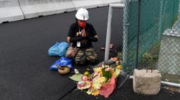 Seorang pawang hujan melakukan ritual saat sesi latihan bebas MotoGP Indonesia di Sirkuit Mandalika, Mandalika, Lombok Tengah, Nusa Tenggara Barat, Jumat (18/3/2022). (AFP/Bay Ismoyo)