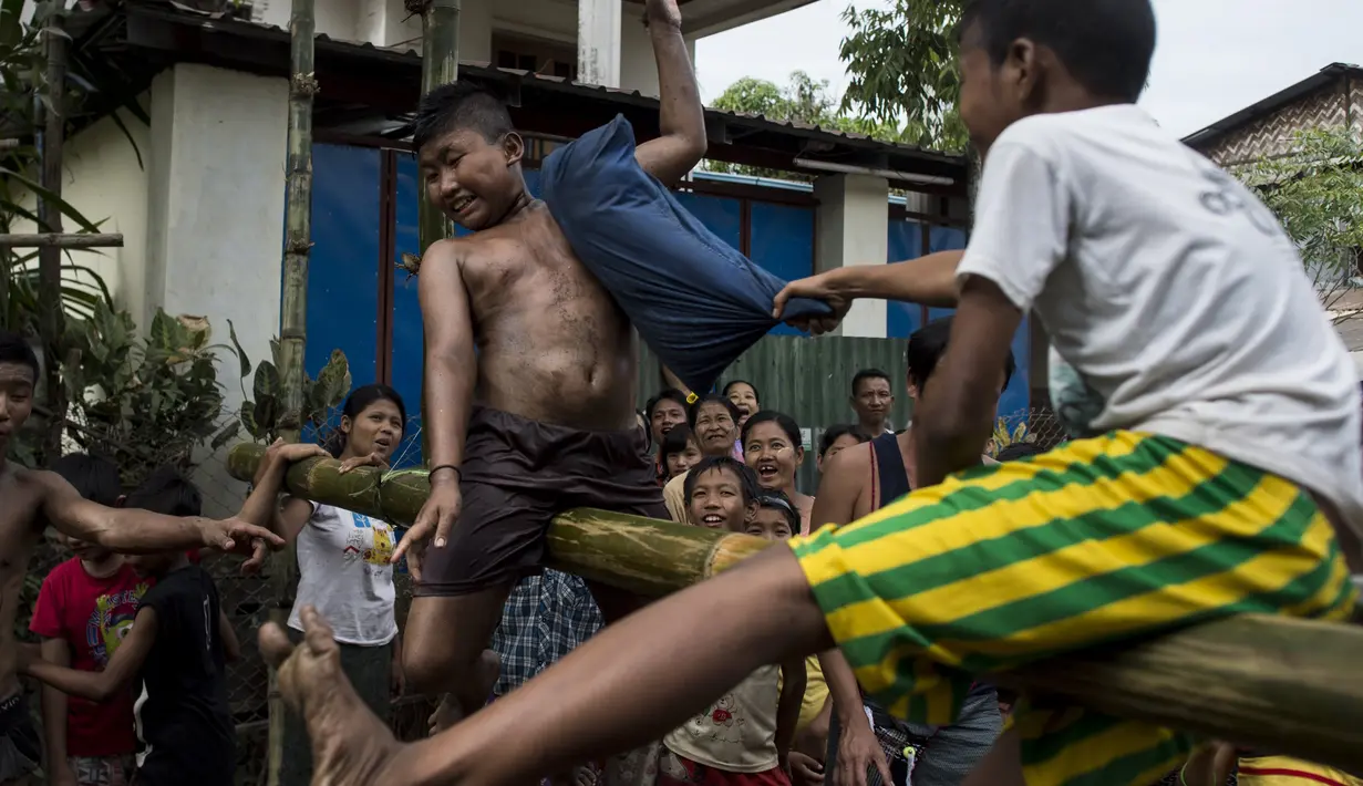 Seorang anak terpukul bantal saat mengikuti Perang Bantal di Yangon, Rabu (4/1). Acara tersebut digelar dalam rangka HUT Kemerdekaan Myanmar ke-69. (AFP PHOTO / YE AUNG THU)