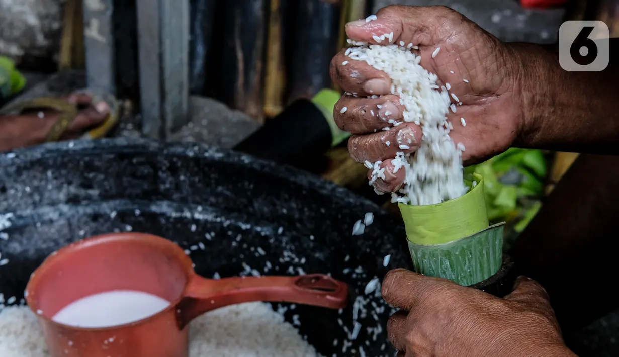 Pekerja memasukan beras ke dalam bambu yang dibungkus daun pisang di industri pembuatan lemang kawasan Senen, Jakarta, Selasa (27/4/2021). Jumlah ini menurun sebelum kondisi pandemi, dimana biasanya memasuki bulan puasa tempat ini bisa membuat lemang 500 batang per hari. (Liputan6.com/Johan Tallo)