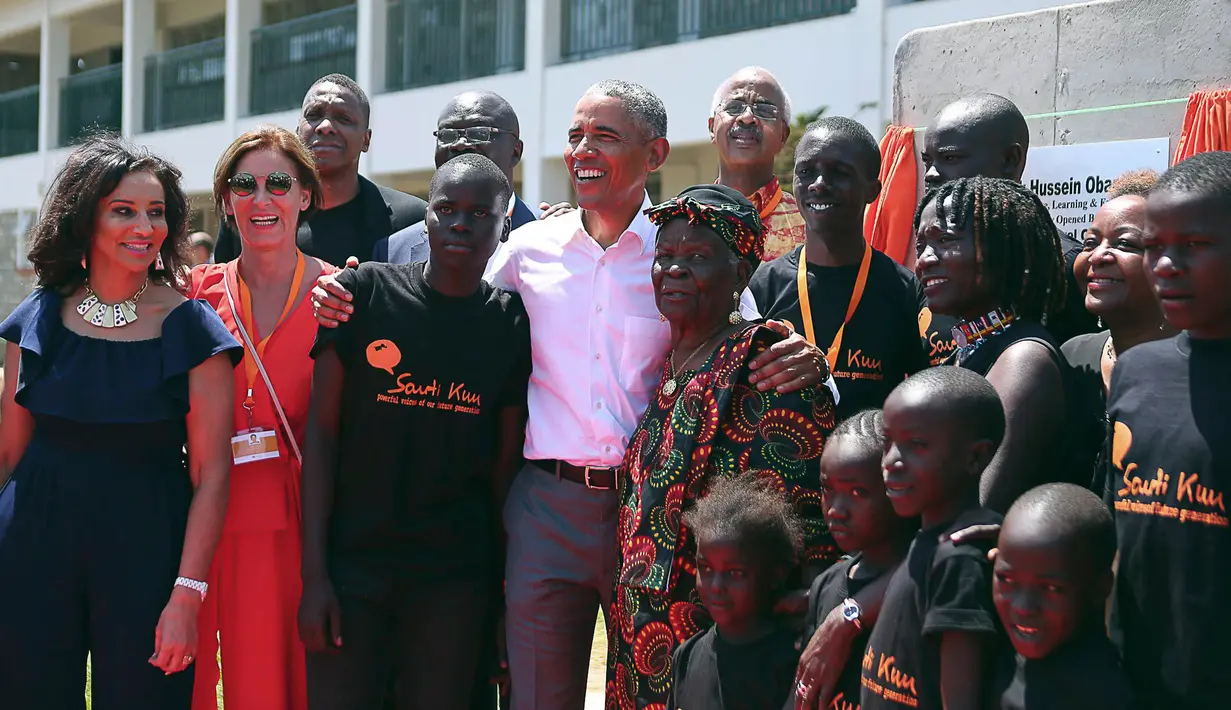 Mantan Presiden AS, Barack Obama berfoto bersama nenek tirinya, Sarah dan sang adik tiri, Auma pada acara di Kogelo, Kenya, Senin (16/7). Obama menghadiri peresmian pusat pelatihan dan olahraga yayasan Sauti Kuu yang didirikan Auma. (AP/Brian Inganga)