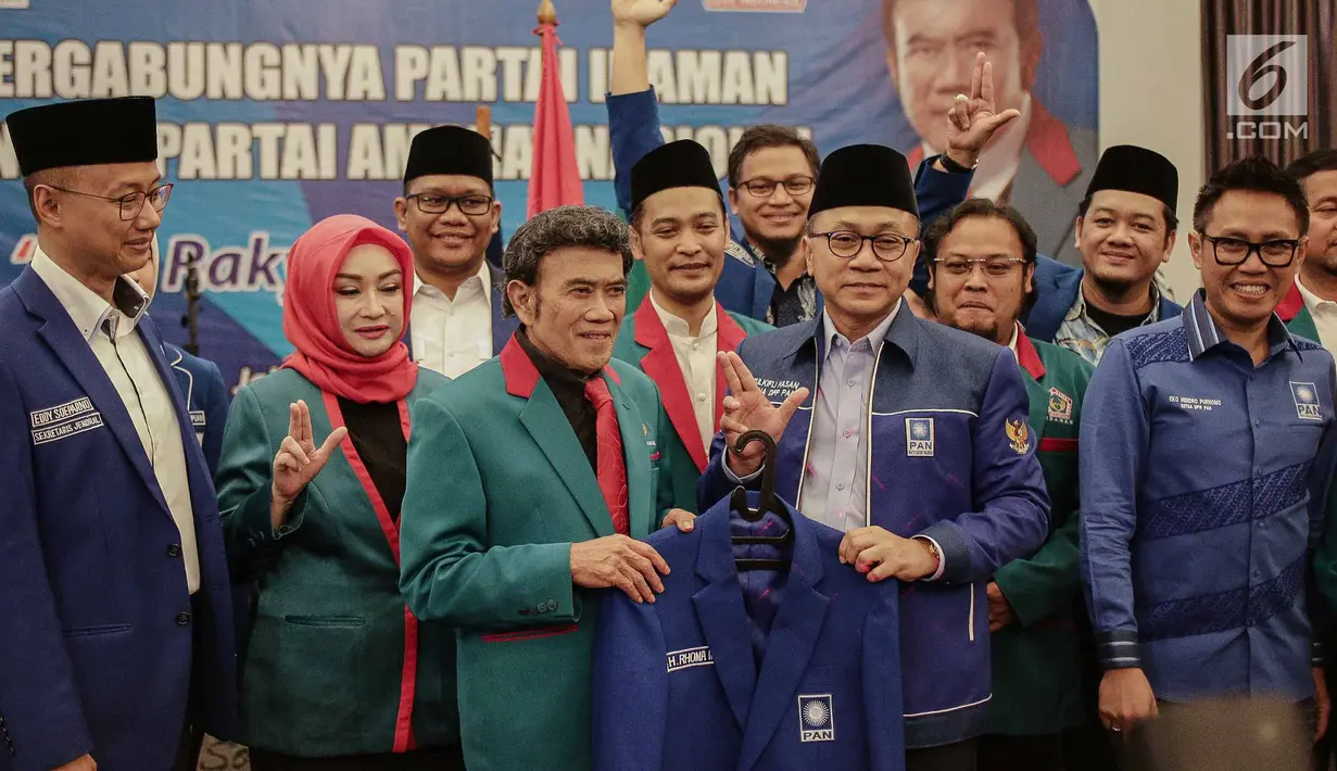 Ketum PAN dan Ketum Partai Idaman Rhoma Irama memegang jas sambil berfoto bersama kadernya saat deklarasi bergabungnya Partai Idaman ke PAN di Jakarta, Sabtu (12/5). (Liputan6.com/Faizal Fanani)