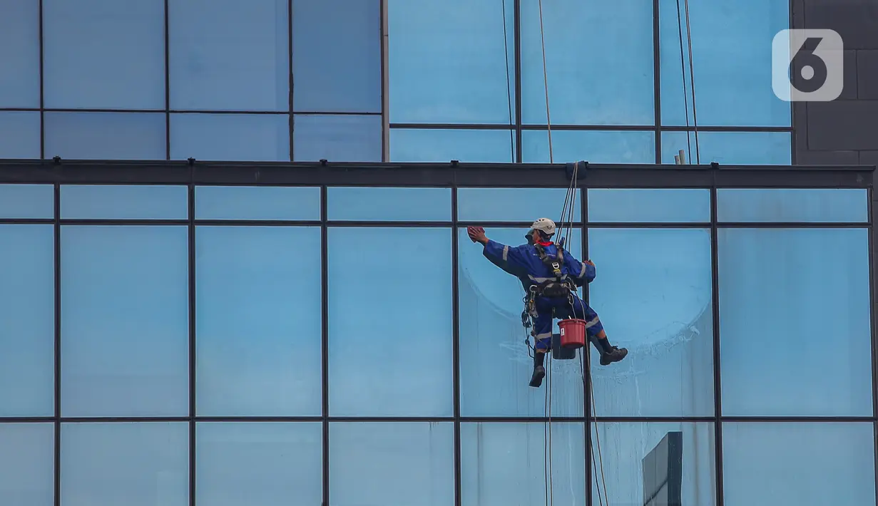 Pekerja tengah melakukan perawatan gedung bertingkat di Kawasan Thamrin, Jakarta, Kamis (13/6/2024). (Liputan6.com/Angga Yuniar)