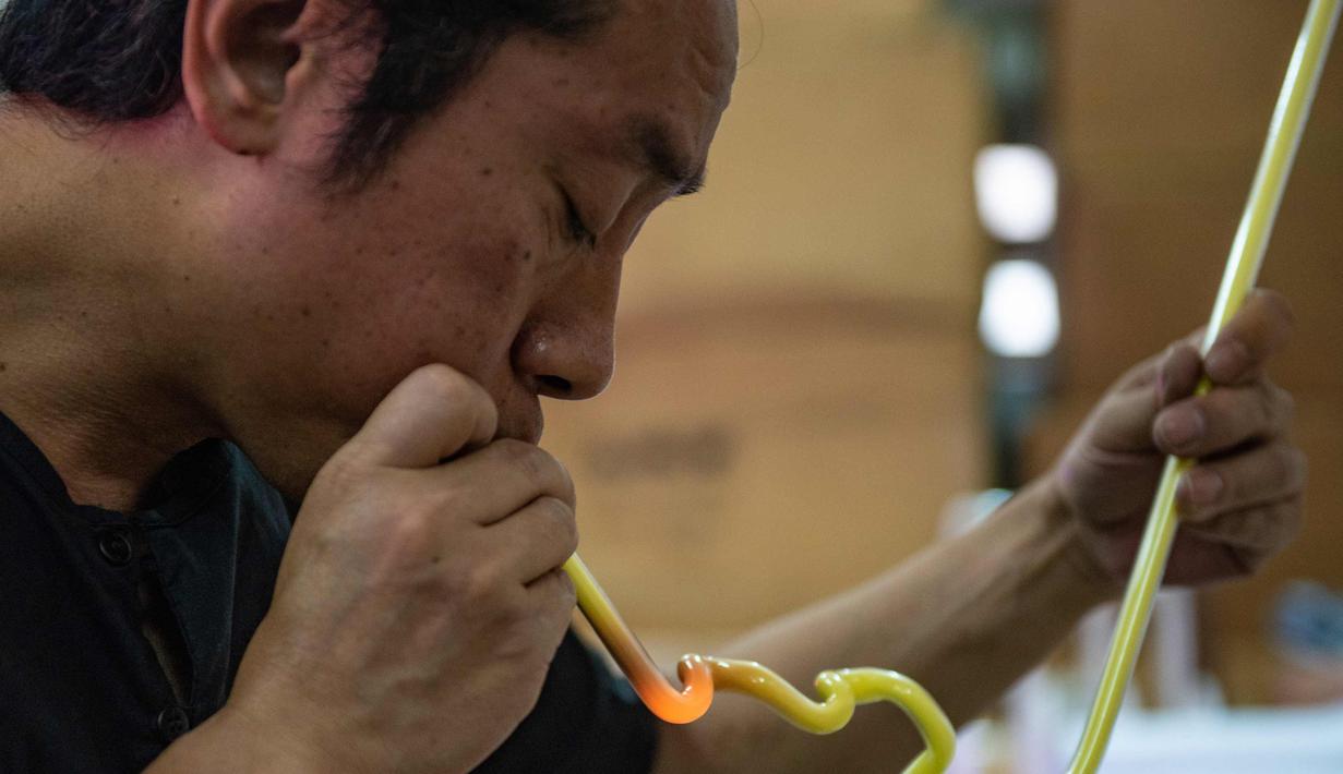 Wu Chi-kai mendemonstrasikan bagaimana membuat neon sign selama wawancara dengan AFP di Hong Kong (16/4). Kota Hong Kong  tidak pernah benar-benar kehilangan kegelapannya berkat cahaya 24 jam dari segudang neon sign. (AFP Photo/Philip Fong)