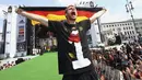Pemain belakang Timnas Jerman, Per Mertesacker, berdiri dan berteriak saat perayaan kemenangan Der Panzer di Berlin, (15/7/2014). (REUTERS/Alex Grimm/Pool)