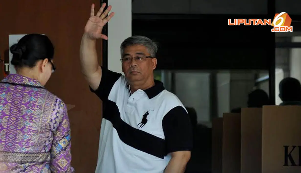 Akil Mochtar melambaikan tangannya ke arah kamera wartawan usai mencoblos di Gedung KPK (Liputan6.com/Johan Tallo)