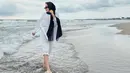 Berada di pantai, ia mengenakan pashmina dipadukan atasa oversize kemeja dan celana putih.(@cita_citata)