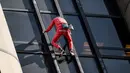Alain Robert, pendaki bangunan pencakar langit asal Prancis memanjat Menara Montparnasse di Paris, Prancis, Rabu (12/10/2022). Alain Robert yang dikenal sebagai Spiderman Prancis itu kembali beraksi dengan memanjat Menara Montparnasse yang memiliki ketinggian 210 meter. (Bertrand GUAY/AFP)