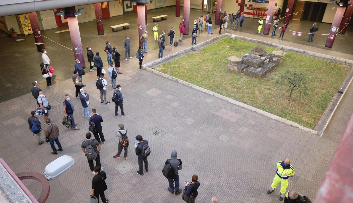 Petugas mengatur arus penumpang di Stasiun Kereta Bawah Tanah Anagnina, Roma, Italia, Senin (18/5/2020). Italia secara perlahan melonggarkan kebijakan lockdown akibat pandemi virus corona COVID-19. (Mauro Scrobogna/LaPresse via AP)