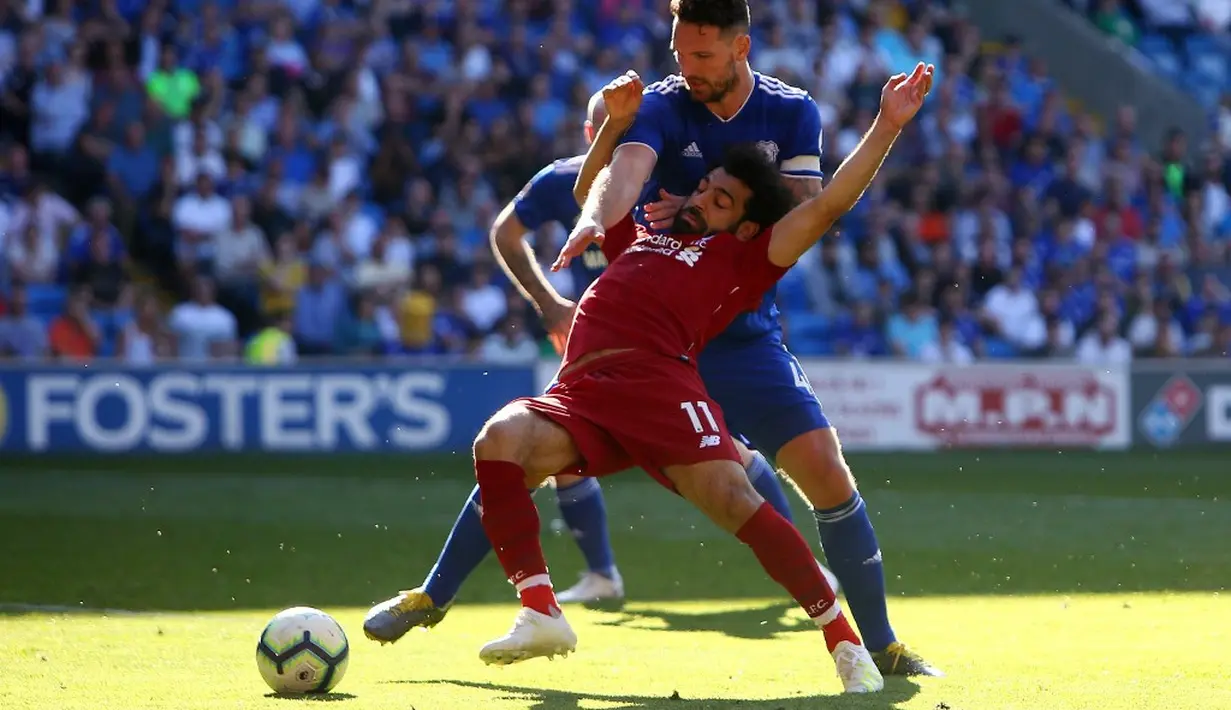 Mohammed Salah dilanggar oleh pemain Cardiff City, Sean Morrison pada laga lanjutan Premier League yang berlangsung di Stadion Millenium, Cardiff, Minggu (21/4). Liverpool menang 2-0 atas Cardiff City. (AFP/Geoff Caddick)