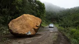 Sebuah batu besar terletak di jalan, sehari setelah gempa bumi di dekat Chinicuila, negara bagian Michoacan, Meksiko, Selasa (20/9/2022). Dua orang tewas dan puluhan bangunan rusak oleh gempa berkekuatan Magnitudo 7,6 yang mengguncang Meksiko pada peringatan dua gempa dahsyat, kata pihak berwenang Selasa. (AP Photo/Armando Solis)