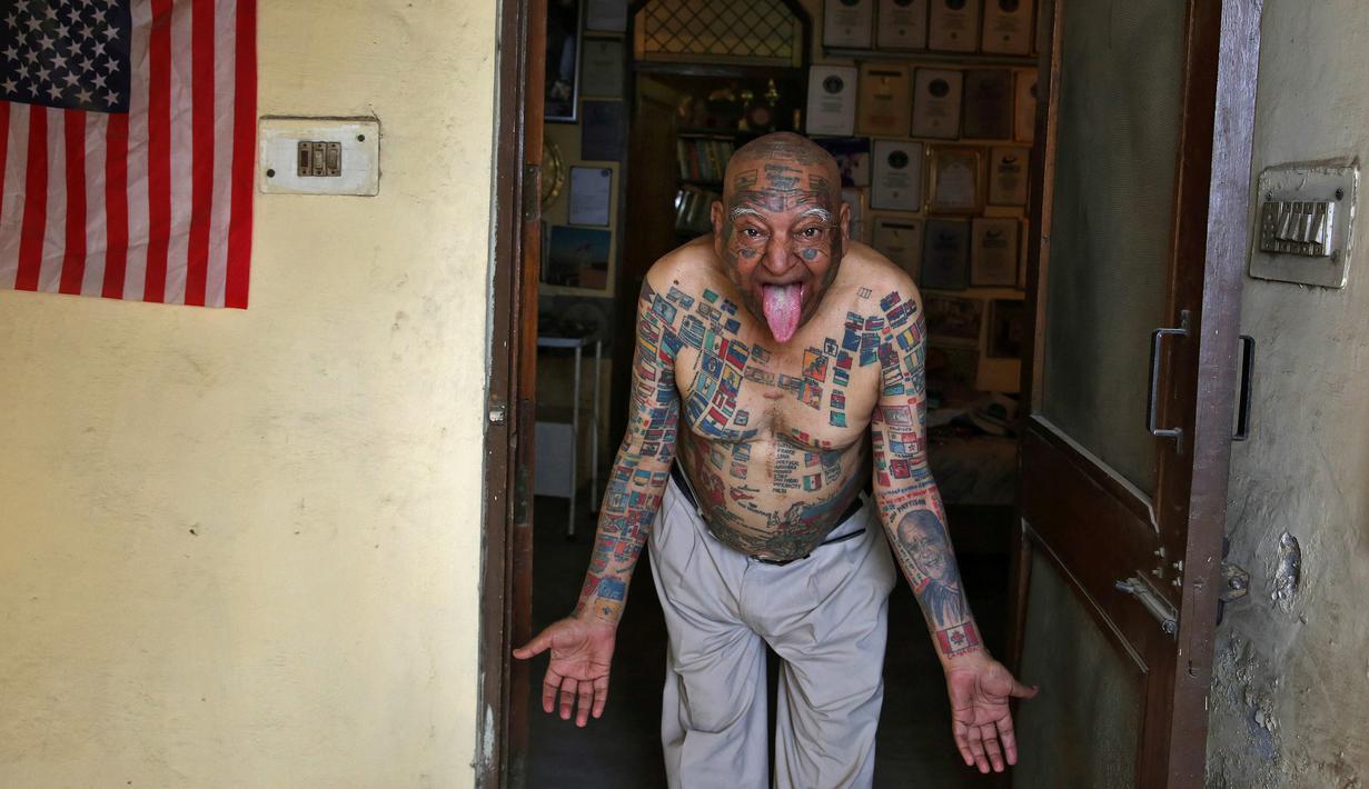 Guinness Rishi, kakek berumur 74 tahun ini mengeluarkan lidahnya di apartemennya di New Delhi, India (20/5). Guinness Rishi merupakan pemegang rekor dunia yang paling banyak menato bendera negara dari seluruh dunia. (REUTERS/Cathal McNaughton)