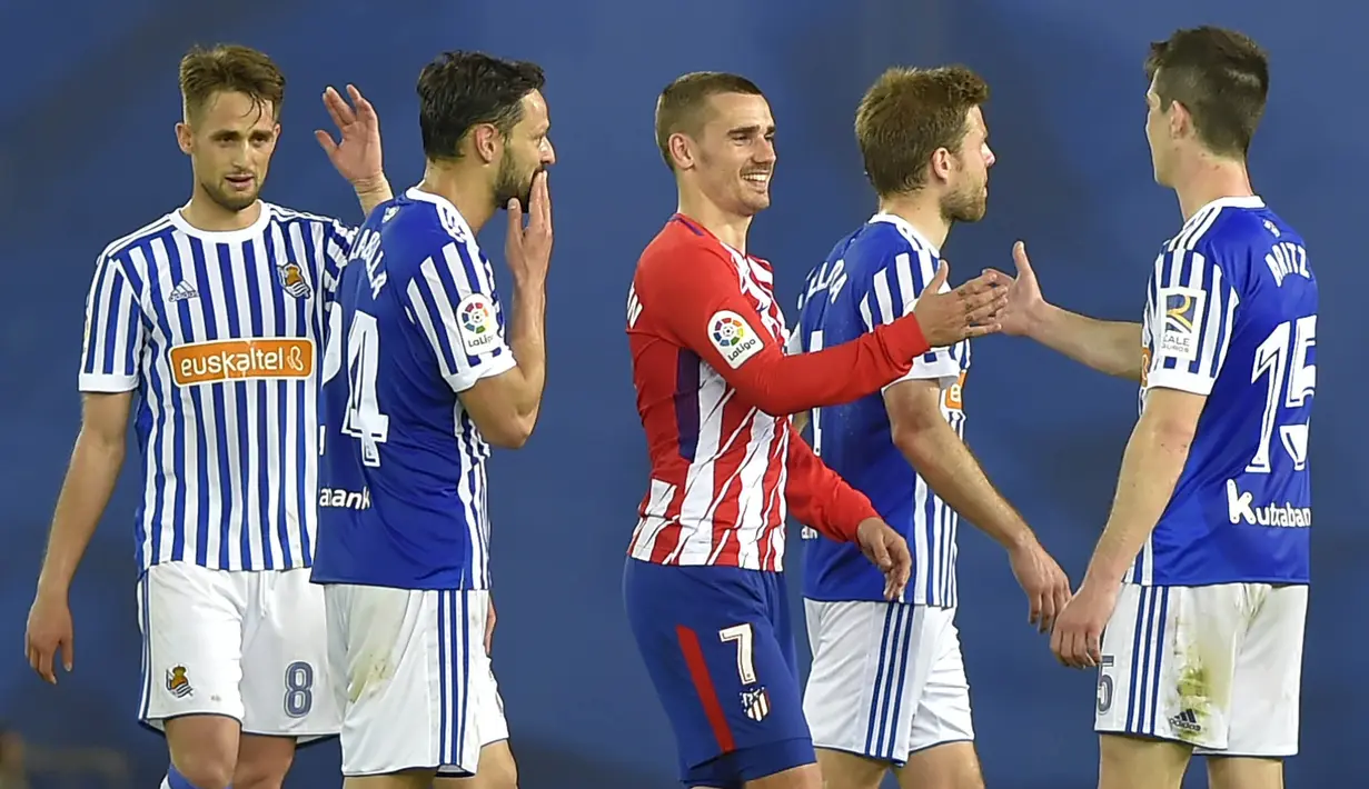 Striker Atletico Madrid, Antoine Griezmann, bersalaman dengan para pemain Real Sociedad pada laga La Liga di Stadion Municipal de Anoeta, Kamis (19/4/2018). Real Sociedad menang 3-0 atas Atletico Madrid. (AFP/Ander Gillenea)