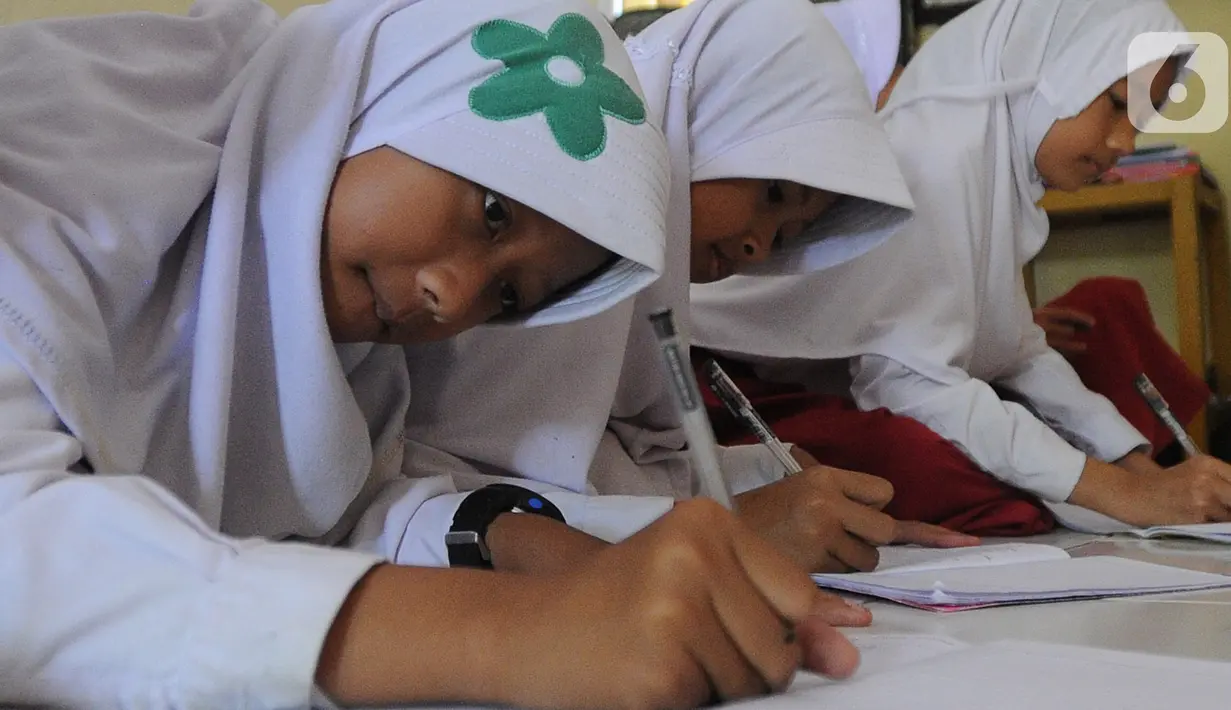 Aktivitas belajar mengajar siswa kelas VI  Madrasah Ibtidaiyah Mathlaul Anwar Ciangsana di lantai tanpa meja dan kursi pada bangunan majelis taklim, Tenjolaya, Kabupaten Bogor, Selasa(22/10/2019).  Kegiatan itu karena dua dari lima ruang kelas yang ada sudah rusak dan lapuk (merdeka.com/Arie Basuki)