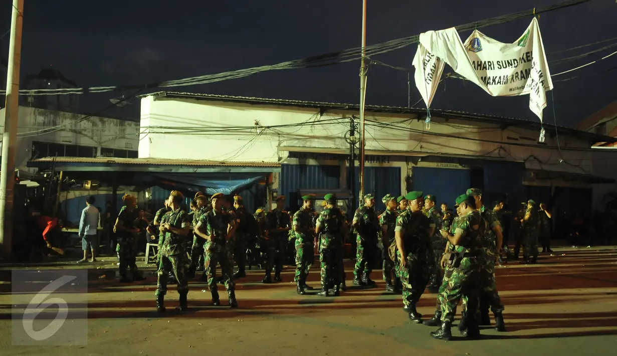 Anggota TNI bersiaga sebelum eksekusi penertiban permukiman di Pasar Ikan, Penjaringan, Jakarta, Senin (11/4). Sebanyak 4.218 personel gabungan TNI, polisi dan Satpol PP dikerahkan untuk mengamankan proses penertiban tersebut (Liputan6.com/Gempur M Surya)