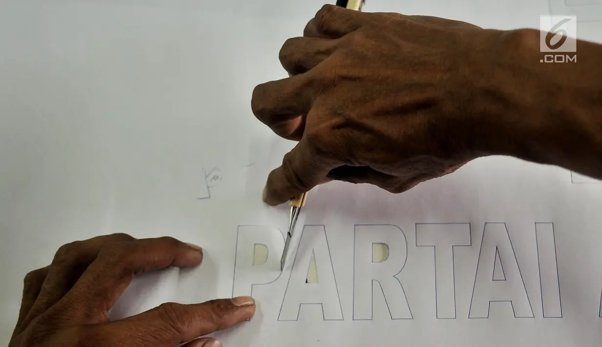 Pekerja mencetak huruf saat menyelesaikan sablon bendera partai politik di Percetakan Andalas Jaya, Jakarta, Rabu (2/1). Tahun politik membawa berkah bagi pengusaha sablon bendera dan spanduk partai. (Merdeka.com/Iqbal Nugroho)