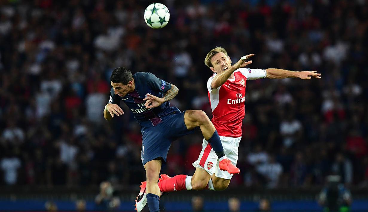 Gelandang PSG, Angel Di Maria, duel udara dengan bek Arsenal, Nacho Monreal. Meski unggul, PSG tetap berupaya melakukan serangan-serangan ke pertahanan The Gunners. (AFP/Franck Fife)