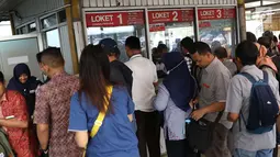 Sejumlah calon penumpang antre membeli tiket kertas di Stasiun Depok Baru, Jawa Barat, Senin (23/7). Pembaruan sistem pembelian tiket elektronik memaksa penumpang membeli tiket kertas seharga Rp3.000 untuk semua stasiun. (Liputan6.com/Immanuel Antonius)