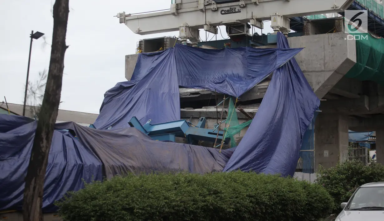 Terpal menutupi box girder beton proyek light rapid transit (LRT) yang roboh di Kayu Putih, Jakarta Timur, Senin (22/1). Puluhan pekerja lainnya langsung berhenti ketika beton yang tengah dipasang ambruk. (Liputan6.com/Arya Manggala)