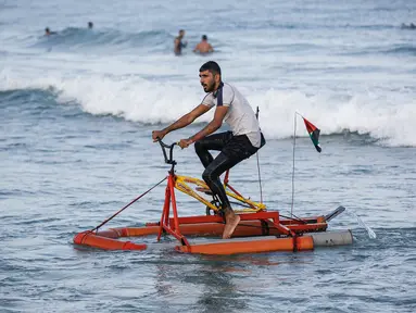 Nelayan Palestina menguji perahu kayuh yang dibuat khusus dari bahan daur ulang di sepanjang pantai di Beit Lahia, Jalur Gaza pada 29 September 2020. (Photo by MOHAMMED ABED / AFP)