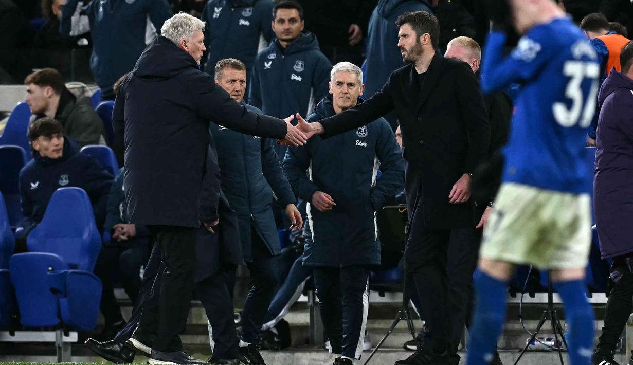 Bertamu ke markas Everton, Setan Merah menang dengan skor tipis 0-1. Tampak dalam foto, manajer Everton asal Skotlandia, David Moyes (kiri), berjabat tangan dengan pelatih sementara Manchester United asal Inggris, Michael Carrick, setelah pertandingan pekan ke-27 Liga Primer Inggris 2025/2026 di Stadion Hill Dickinson, Liverpool, barat laut Inggris, Senin 23 Februari 2026 waktu setempat atau Selasa 24 Februari 2026 dini hari WIB. (Paul ELLIS/AFP)