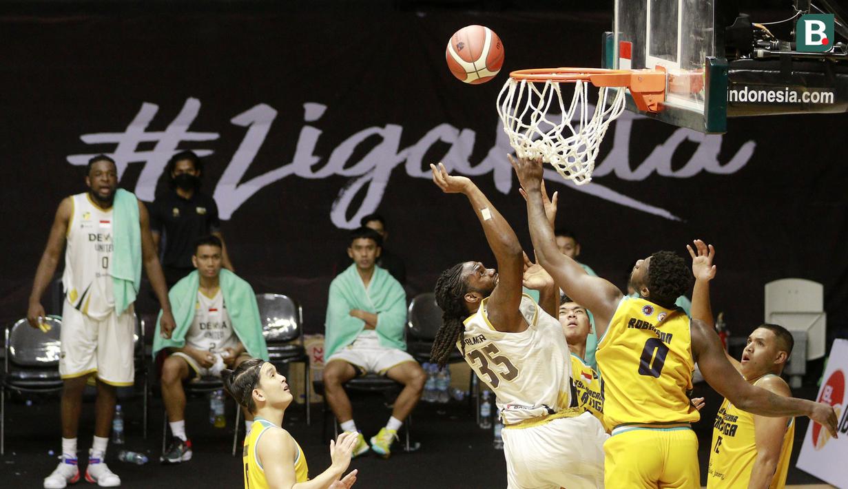 Pemain Dewa United Surabaya, Darryl James Palmer (kiri) berusaha memasukkan bola saat melawan Satya Wacana Salatiga dalam laga IBL 2022 di Hall Basket GBK, Jakarta, Selasa (18/1/2022). Dewa United menang dengan skor 66-64. (Bola.com/M Iqbal Ichsan)