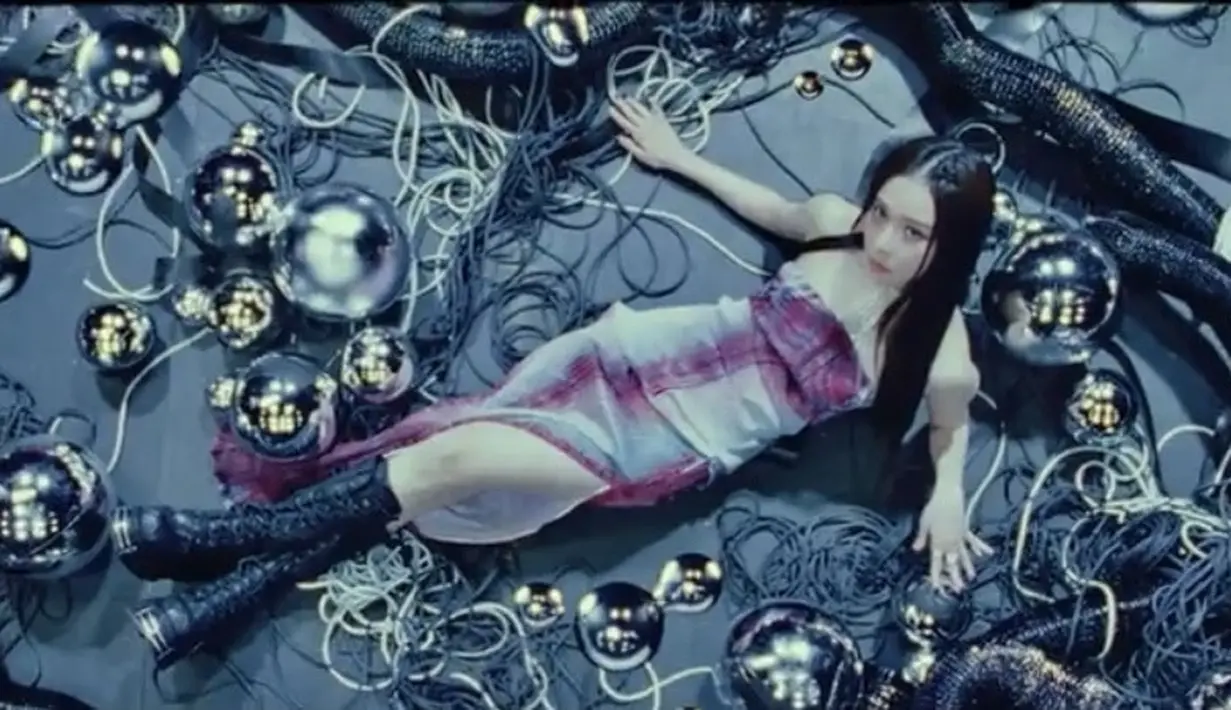 Dalam track video tersebut, Winter tampil dengan slit dress bodycon didominasi warna merah dan putih. Ia memadukan penampilannya dengan knee boots hitam. Credit: Instagram (@aespa_official)