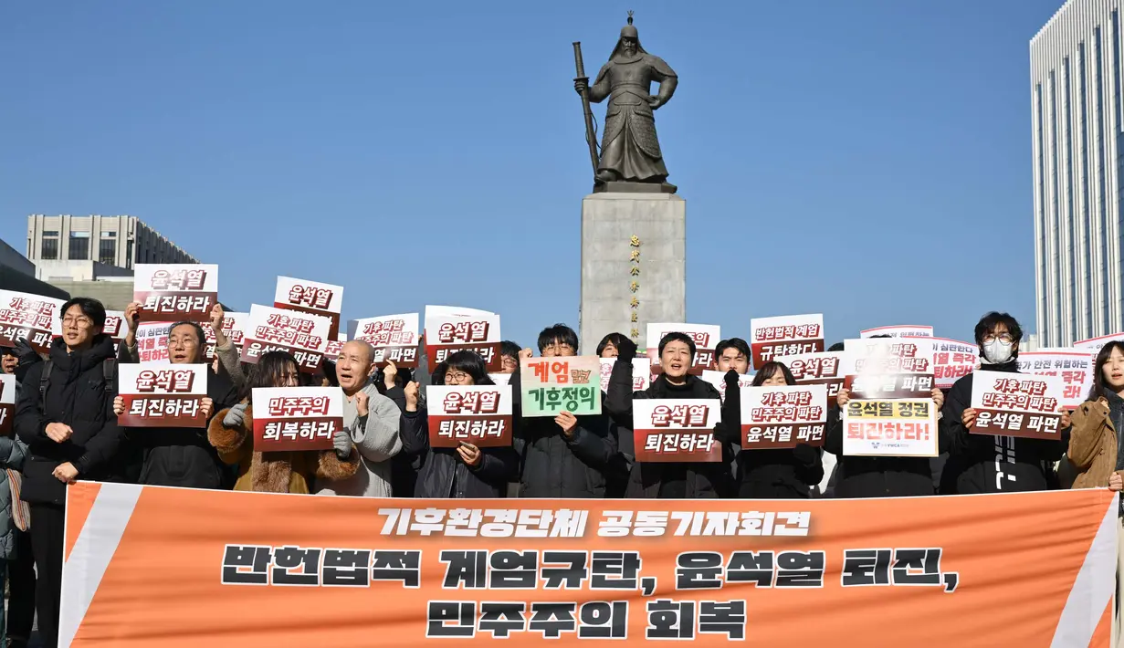 Para pengunjuk rasa memegang plakat dalam unjuk rasa yang menyerukan pengunduran diri Presiden Korea Selatan Yoon Suk Yeol di Lapangan Gwanghwamun di Seoul pada 4 Desember 2024. (ANTHONY WALLACE/AFP)