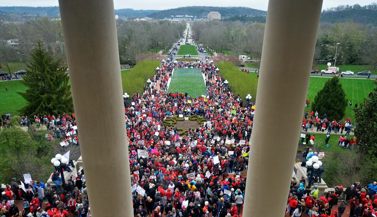 Ribuan guru dari seluruh  Kentucky berkumpul di luar gedung DPR negara bagian saat menggelar aksi unjuk rasa di Frankfort, Amerika Serikat, Senin (2/4). Mereka turun ke jalan menuntut kenaikan gaji dan pendanaan bagi sekolah. (AP/Timothy D. Easley)