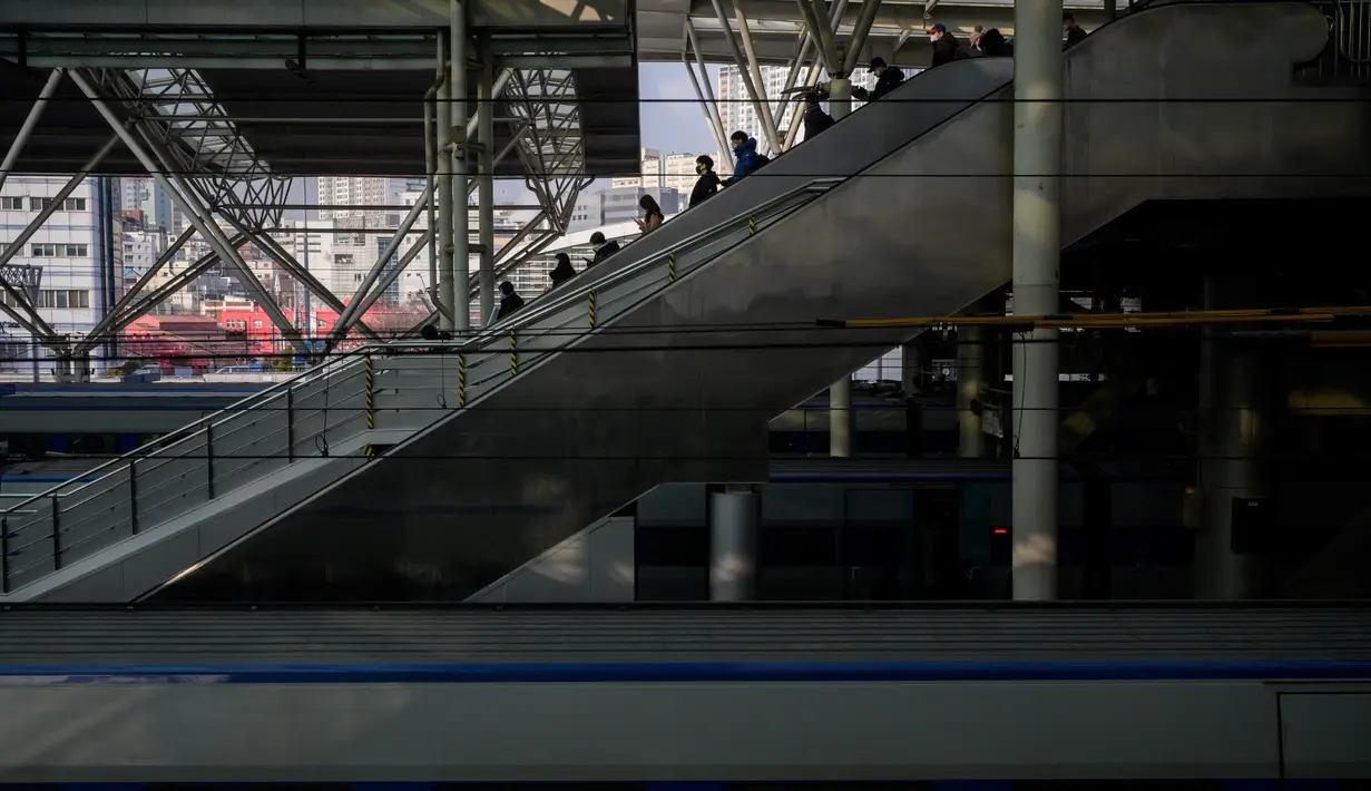 Penumpang menuruni eskalator di stasiun kereta api Seoul, menjelang liburan Tahun Baru Imlek pada Rabu (10/2/2021). Liburan Tahun Baru Imlek dimulai pada 11 Februari, dan puluhan juta orang Korea Selatan biasanya melakukan perjalanan ke seluruh negeri untuk pertemuan keluarga. (Ed JONES/AFP)