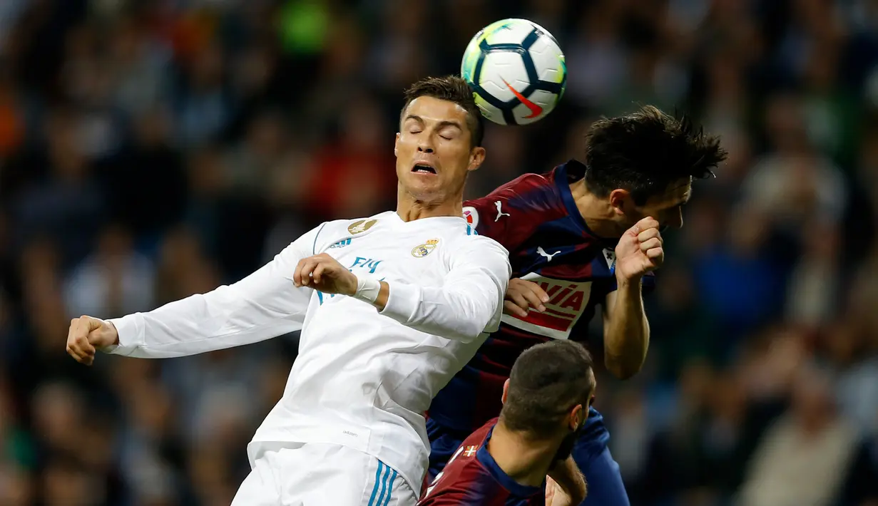 Pemain Real Madrid, Cristiano Ronaldo berebut bola dengan pemain Eibar, Paulo Oliveira dalam lanjutan La Liga pekan kesembilan di Stadion Santiago Bernabeu, Minggu (22/10). Madrid menang tiga gol tanpa balas. (AP/Francisco Seco)