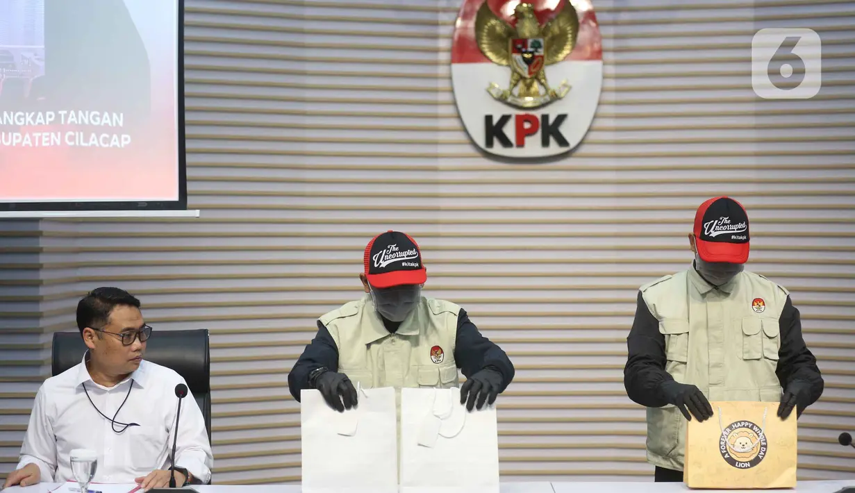 Bupati Cilacap Syamsul Auliya Rachman ditetapkan sebagai tersangka terkait dugaan pemerasan dan penerimaan lainnya di lingkungan Pemerintah Kabupaten Cilacap, Jawa Tengah. Tampak dalam foto, Deputi Bidang Penindakan dan Eksekusi Komisi Pemberantasan Korupsi (KPK), Asep Guntur Rahayu (kiri) menyaksikan petugas yang akan memperlihatkan barang bukti yang disita dari Operasi Tangkap Tangan (OTT) terhadap Bupati Cilacap, Jawa Tengah, Syamsul Auliya Rachman, di Gedung Merah Putih KPK, Jakarta, Sabtu (14/3/2026). (Liputan6.com/Helmi Fithriansyah)