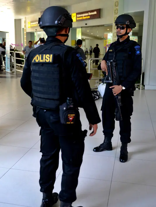 Dua personil kepolisian bersenjata berjaga di Bandara Ngurah Rai, Denpasar, Bali, Jumat (15/1). Pasca peristiwa serangan di Sarinah, Jakarta, pengelola Bandara Internasional I Gusti Ngurah Rai, Bali perketat pengamanan. (AFP PHOTO/Sonny Tumbelaka)