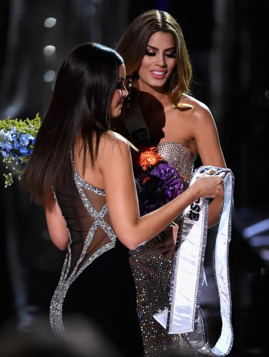 Miss Universe 2014 Paulina Vega saat melepaskan selempang Miss Kolombia, Ariadna Gutierrez Vega akibat kesalahan fatal MC yang salah menyebut nama pemenang Miss Universe 2015 di The AXIS Las Vegas, Minggu (20/12). (Ethan Miller/Getty Images/AFP)