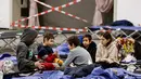 Anak-anak duduk di tempat tidur di pusat pengungsi dari Ukraina di Messe di Berlin, Jerman pada 11 Maret 2022. Badan PBB untuk urusan pengungsi (UNHCR) mengatakan setidaknya 2,5 juta orang telah meninggalkan Ukraina, dengan lebih dari setengahnya sekarang di Polandia. (Odd ANDERSEN / AFP)
