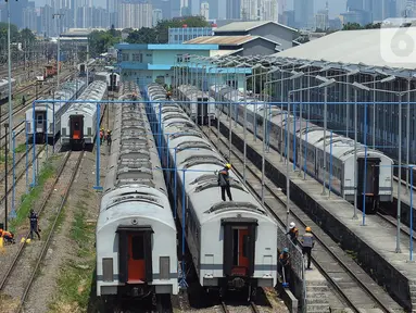 Pekerja mencuci rangkaian gerbong kereta yang terparkir di Depo Cipinang, Jakarta, Jumat (22/9/2023). Depo Cipinang menjadi tempat perawatan kereta terbesar di Indonesia dengan memiliki 28 jalur kereta. (merdeka.com/Imam Buhori)