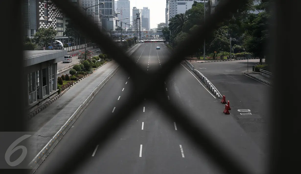 Sebuah taksi melintasi jalan protokol yang lengang di kawasan MH Thamrin, Jakarta, Selasa (6/7). Hampir semua jalan di Ibu Kota lengang saat sebagian besar warga mudik untuk merayakan Lebaran di kampung halaman. (Liputan6.com/Faizal Fanani)