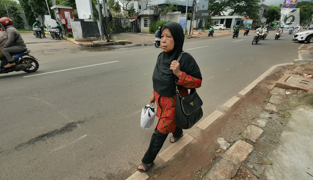 Pejalan kaki berjalan di trotoar kawasan Kemang, Jakarta, Kamis (21/2). Trotoar di Kemang, Jakarta Selatan akan dibangun lebih lebar sehingga ramah pejalan kaki.  (Liputan6.com/Herman Zakharia)
