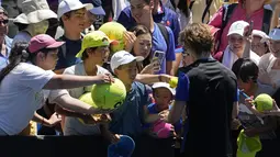 Petenis asal Rusia Andrey Rublev memberikan tanda tangan setelah mengalahkan Dominic Thiem dari Austria pada pertandingan putaran pertama kejuaraan tenis Australia Terbuka di Melbourne, Rabu (18/1/2023). Macam-macam barang pun disodorkan penggemar ke petenis pujaan.  (AP Photo/Ng Han Guan)