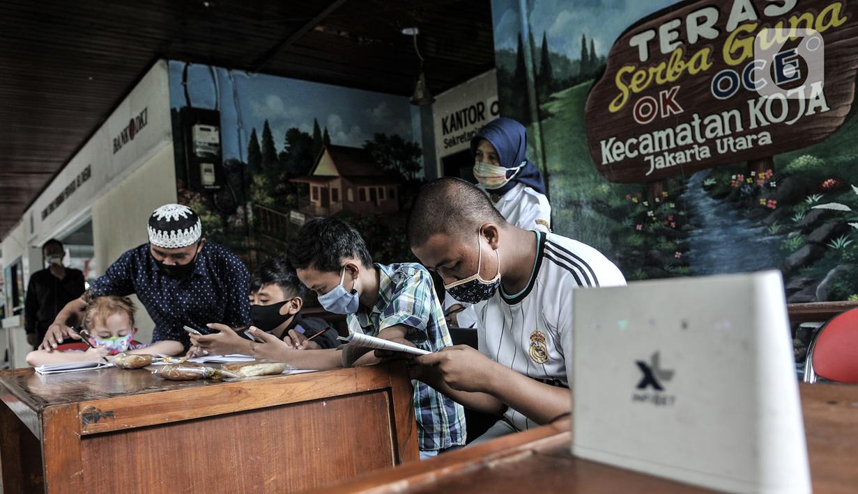 Gus In membimbing siswa saat mengikuti kegiatan belajar jarak jauh di Bank Sampah Majelis Taklim, Kecamatan Koja, Jakarta, Rabu (12/8/2020). Para sisw dapat memakai fasilitas WiFi dengan menukarkan sampah anorganik minimal 1 kilogram. (merdeka.com/Iqbal S. Nugroho)