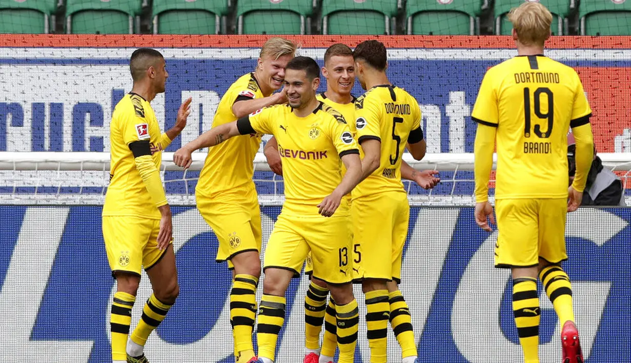 Pemain Borussia Dortmund merayakan gol yang dietak oleh Raphael Guerreiro ke gawang Wolfsburg pada laga Bundesliga, Minggu (24/5/2020). Borussia Dortmund menang 2-0 atas Wolfsburg. (AP/Michael Sohn)