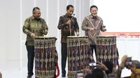 Presiden Joko Widodo (tengah) didampingi Gubernur Bank Indonesia Perry Warjiyo dan Kepala Bekraf Triawan Munaf (kiri) memukul gendang Beleq sebagai tanda peresmian pembukaan pameran Karya Kreatif Indonesia (KKI) 2019 di JCC Senayan, Jumat (12/7/2019). (Liputan6.com/Angga Yuniar)