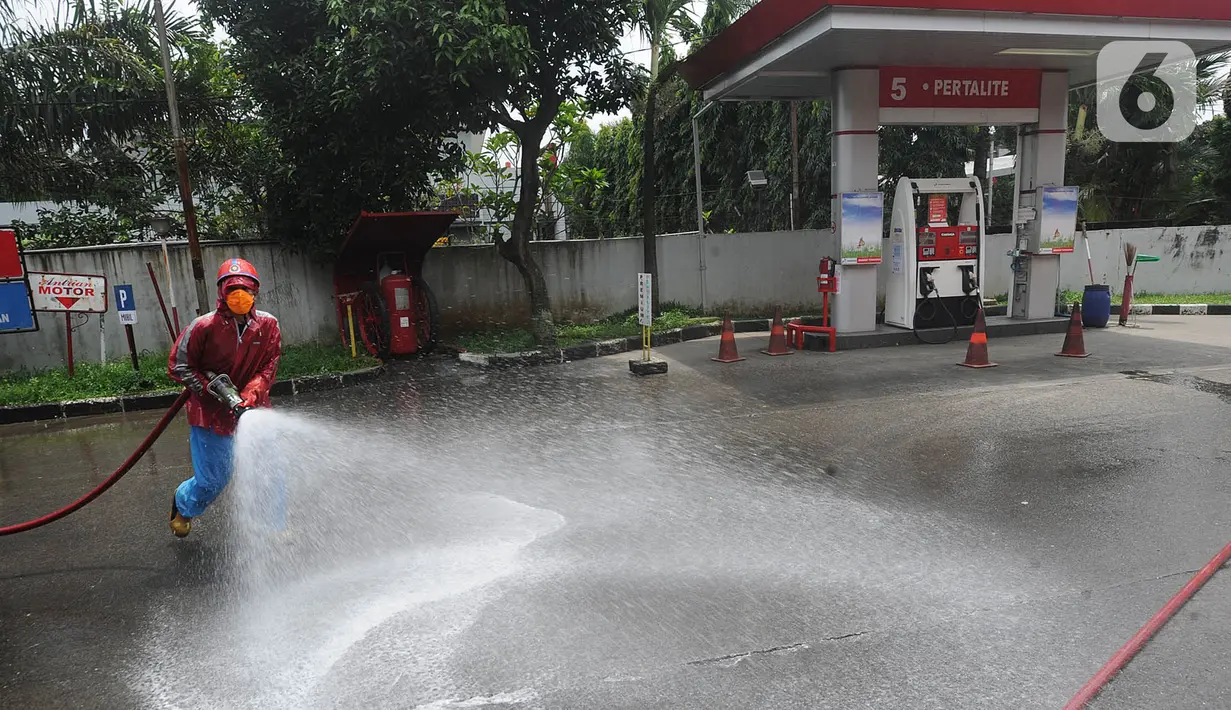 Petugas Pertamina dan Damkar melakukan penyemprotan disinfetaktan di SPBU depan RS Azra, Bogor, Jawa Barat, Jumat (27/03/2020). Hari ini seluruh SPBU di wilayah Bogor dilakukan penyemprotan disinfektan dalam rangka mencegah penyebaran wabah Covid-19. (merdeka.com/Arie Basuki)