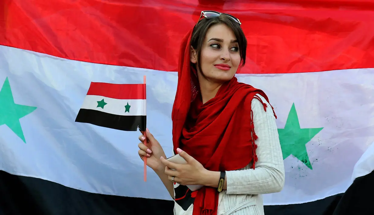 Seorang wanita cantik pendukung Suriah menyaksikan laga kualifikasi Piala Dunia 2018 melawan Iran di Stadion Azadi, Tehran, Selasa (5/9/2017). Finis urutan tiga grup A, Suriah lolos ke babak playoff untuk menantang Australia. (AFP/Atta Kenare)
