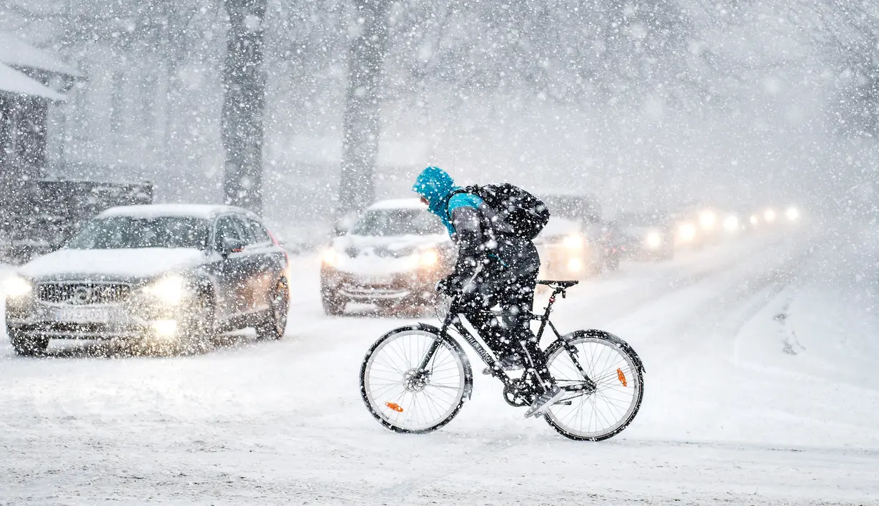 Pengendara sepeda berjuang melewati salju tebal di Aalborg, Denmark, Selasa (27/2). Cuaca dingin di Siberia yang dijuluki "The Beast from the East" membuat suhu di sebagian Eropa menurun. (AFP PHOTO/Scanpix DAN Ritzau SCANPIX/Henning Bagger/Denmark OUT)